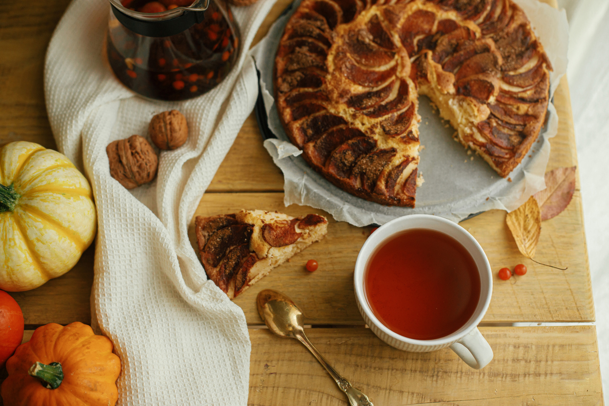 Stoomende mok Dutch Applepie thee met stukjes appel, schijfje sinaasappel en kaneelstokje.”